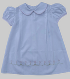 White dress with a Peter Pan collar and floral embroidery on a gray background